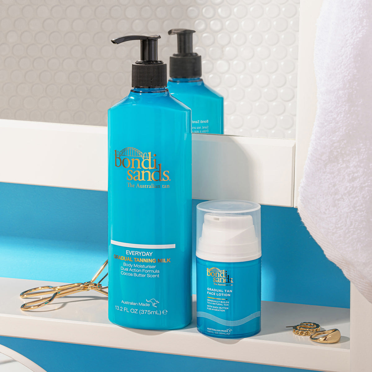 Die Everyday Gradual Tanning Milk (375 ml) und die Gradual Tan Face Lotion von Bondi Sands stehen in einem Badezimmerschrank
