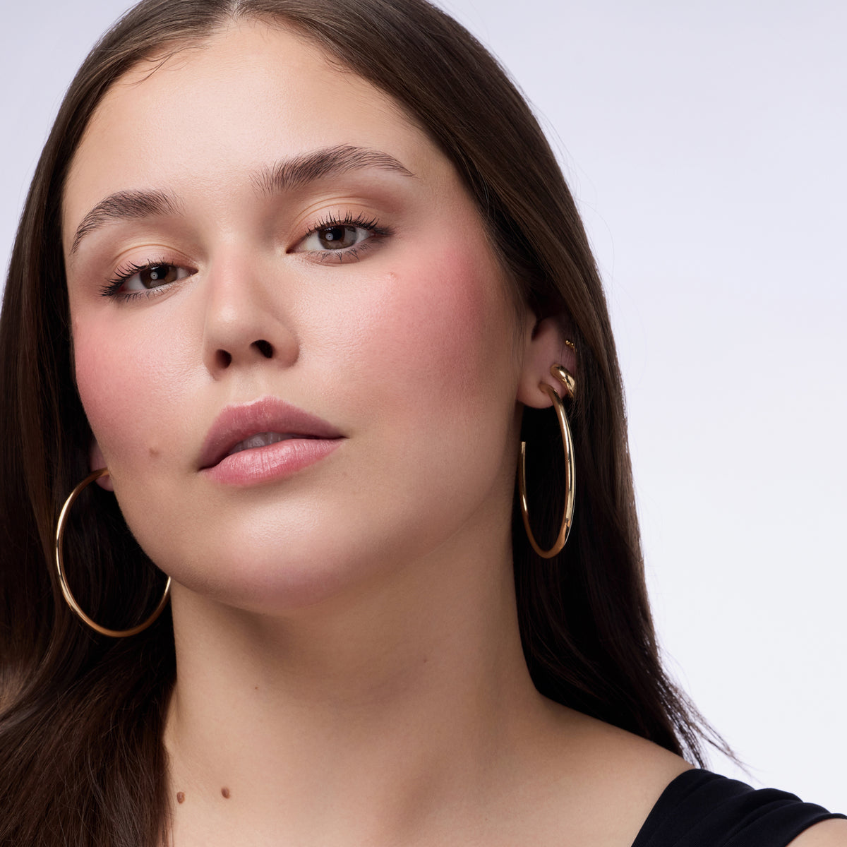 Nahaufnahme einer Frau die den Blushin' Charm Multi Stick 030 auf den Wangen und Lippen trägt.
