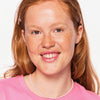Frau mit hellem Teint und roten Haaren präsentiert die DROP OF sunshine BRONZING DROPS.
