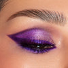 Nahaufnahme eines geschlossenen Auges mit kräftigem, schimmerndem violettem Lidschatten aus der Smoke Sessions II-Palette und einer betonten Augenbraue.