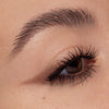 Nahaufnahme eines geschminkten Auges mit weichem, braunem Lidschatten in Cat-Eye-Form und betonten, schwarz getuschten Wimpern.