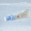 Die Relief Sun Aqua Fresh Rice + B5 SPF 50+ Tube umgeben von Sprudelwasser
