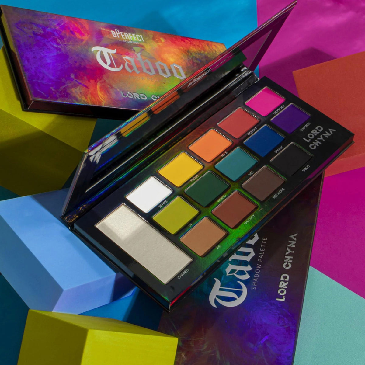 Geöffnete BPerfect Cosmetics x Lord Chyna Taboo Shadow Palette auf farbenfrohem geometrischen Hintergrund.