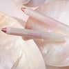 Zwei PEARLFECTION Eyeshadow Sticks von Catrice Cosmetics auf perlmuttartigen Muscheloberflächen.