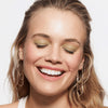 Eine lächelnde Frau mit geschlossenen Augen und gepflegten Augenbrauen durch den Slim'Matic Ultra Precise Brow Pencil Waterproof vor schlichtem Hintergrund.