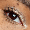 Nahaufnahme eines Auges mit langen, definierten Wimpern und schimmerndem Lidschatten auf dem Lid.