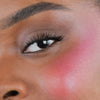 Nahaufnahme des Gesichts einer Person mit rosa Wangen geschminkt mit dem Blush Stick – 2-in-1 Creme Rouge mit Pinsel.
