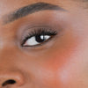 Nahaufnahme des Gesichts einer Person mit rosa Wangen geschminkt mit dem Blush Stick – 2-in-1 Creme Rouge mit Pinsel.