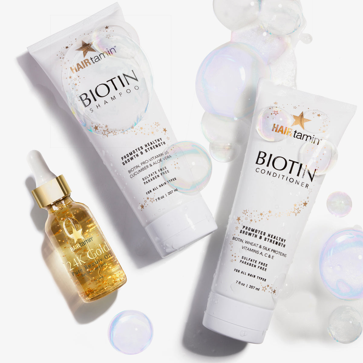 Auf einem weißen Hintergrund sind zwei Tuben HAIRtamin Biotin Shampoo und Conditioner neben Blasen dargestellt.