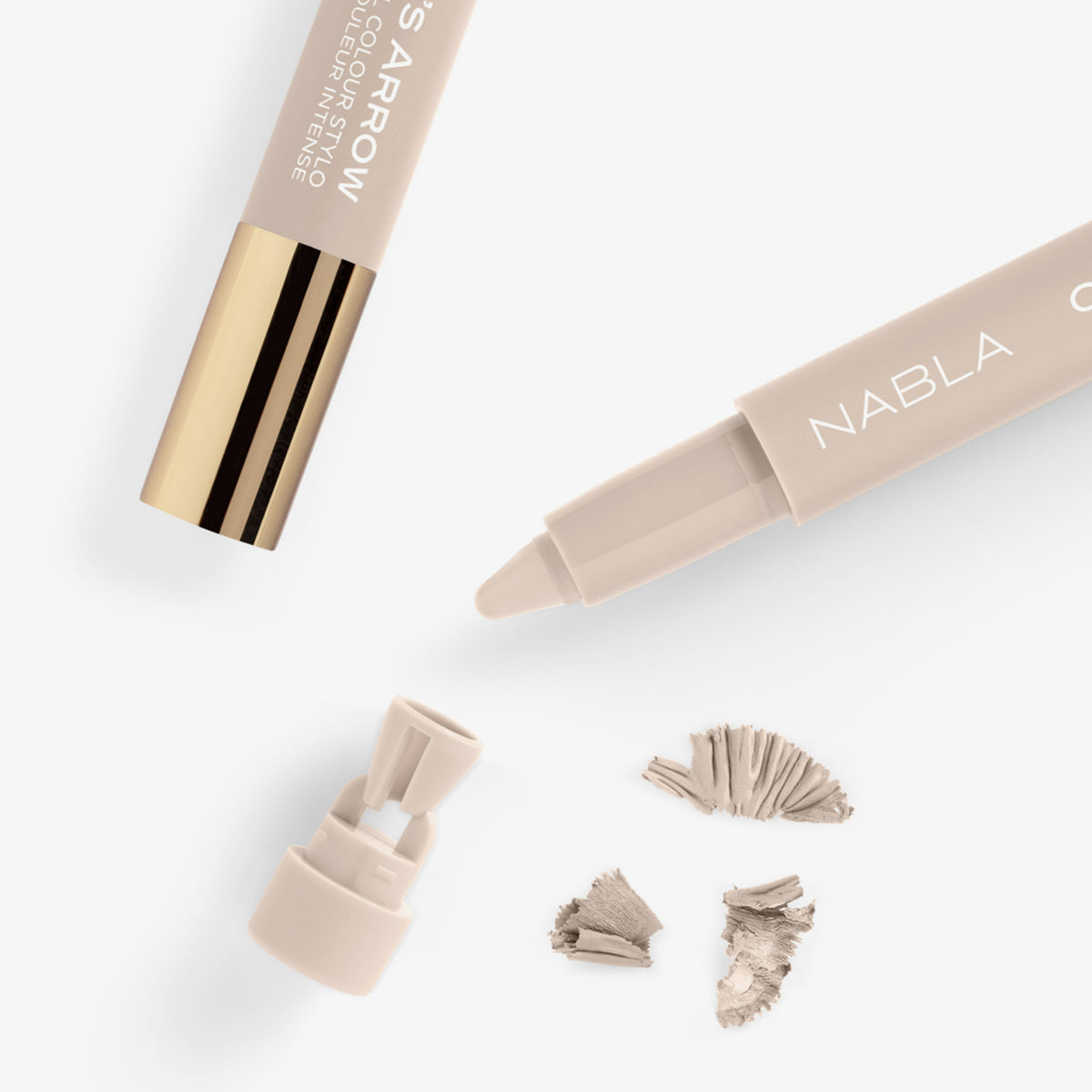 Nahaufnahme eines beigefarbenen NABLA Cupid’s Arrow Stifts mit integrierter Spitze und Spänen – der integrierte Anspitzer ist abgenommen.