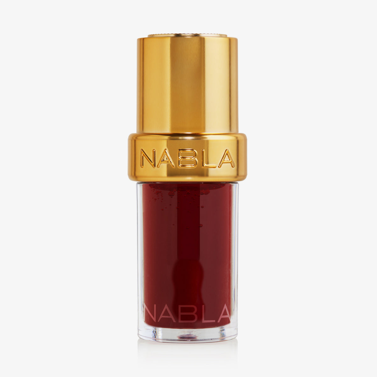 Ein rotes Lip Candy Oil von NABLA Cosmetics in einer durchsichtigen Tube mit goldenem Deckel und der Aufschrift NABLA.