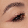 Nahaufnahme eines braunen Auges mit langen Wimpern, einem mit Cupid’s Arrow Longwear Stylo gezogenen Lidstrich und einer gepflegten Augenbraue.