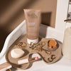 Die Gradual Tanning Lotion Tinted Skin Perfector wird auf einem Tablett mit Schönheitsartikeln präsentiert