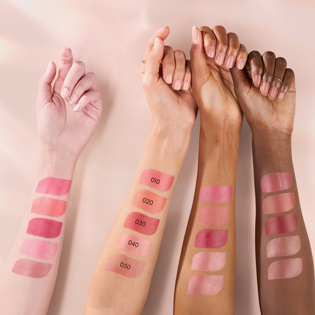 Vier Unterarme unterschiedlicher Hauttöne zeigen Swatches der Blushin' Charm Multi Sticks.