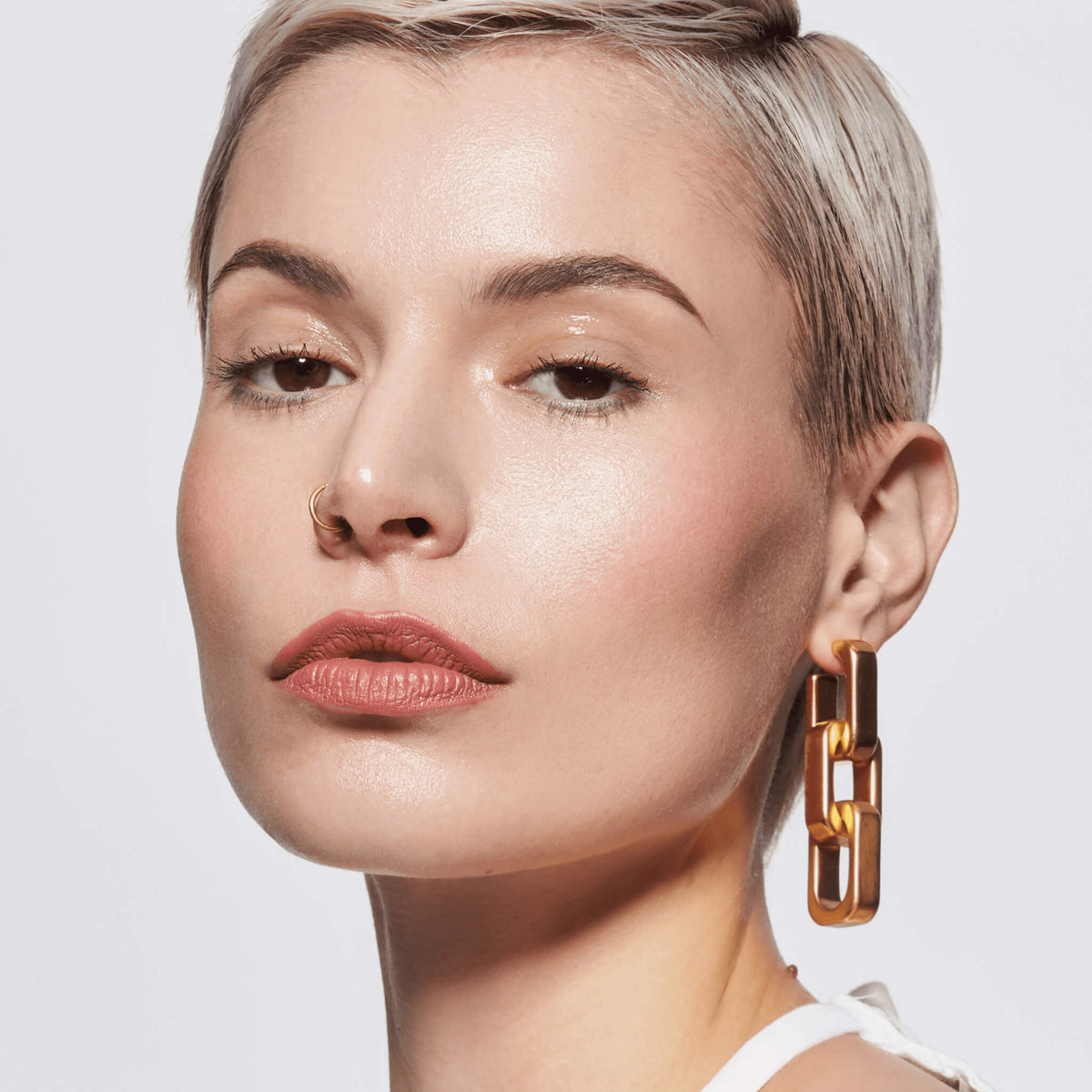 Eine Person mit kurzen Haaren blickt in die Kamera und hat gepflegte Augenbrauen durch den Slim'Matic Ultra Precise Brow Pencil Waterproof.