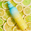 Eine Flasche Feel Pure Exfoliation Cleanser, präsentiert auf Zitronenscheiben vor einem lebendigen, frischen Hintergrund.