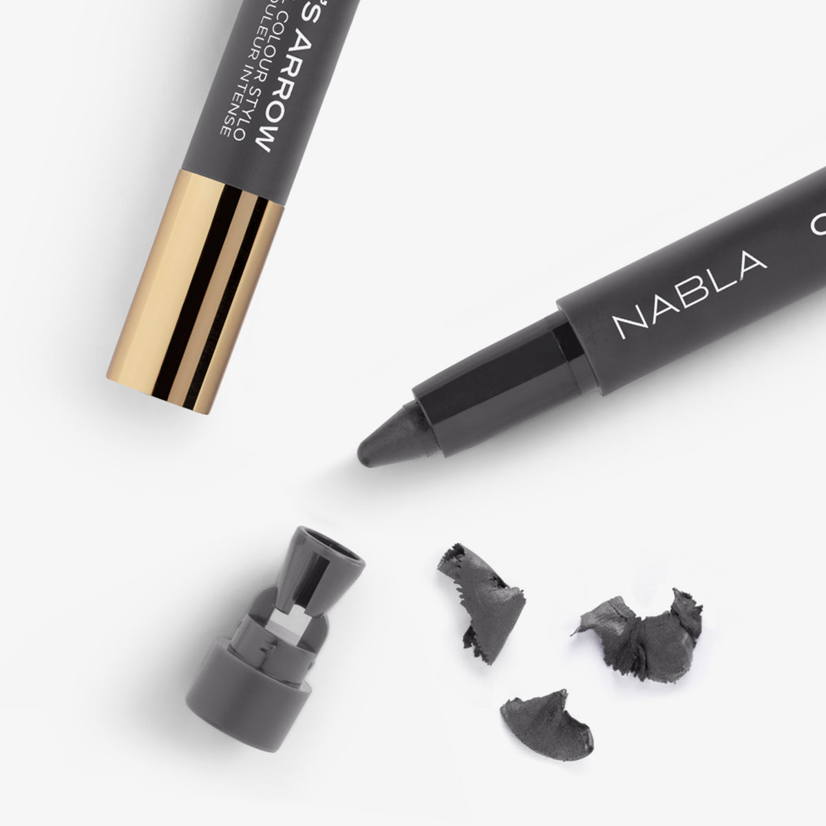 Nahaufnahme eines graufarbenen NABLA Cupid’s Arrow Stifts mit integrierter Spitze und Spänen – der integrierte Anspitzer ist abgenommen.