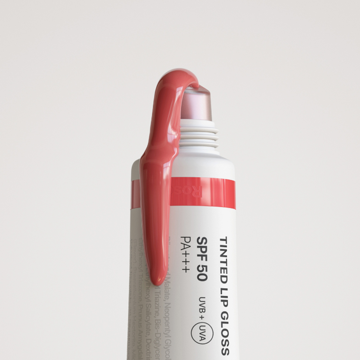 Ein offener Tinted Lipgloss mit LSF 50 und einem Hauch rosa Gloss auf der Kappe.