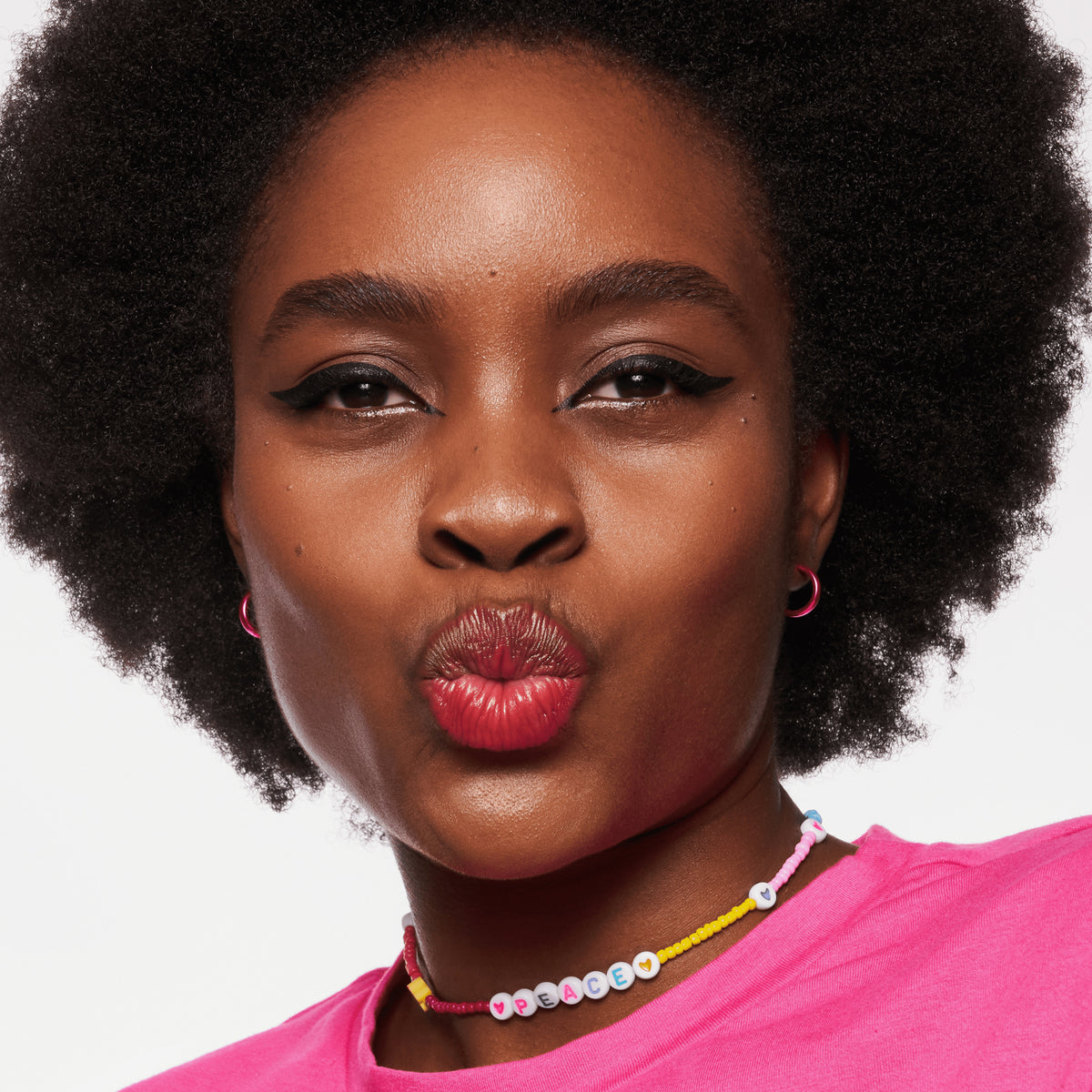 Person mit dunklem Teint und schwarzen Haaren präsentiert den BABY GOT GLOW liquid highlighter 10 auf den Wangen.