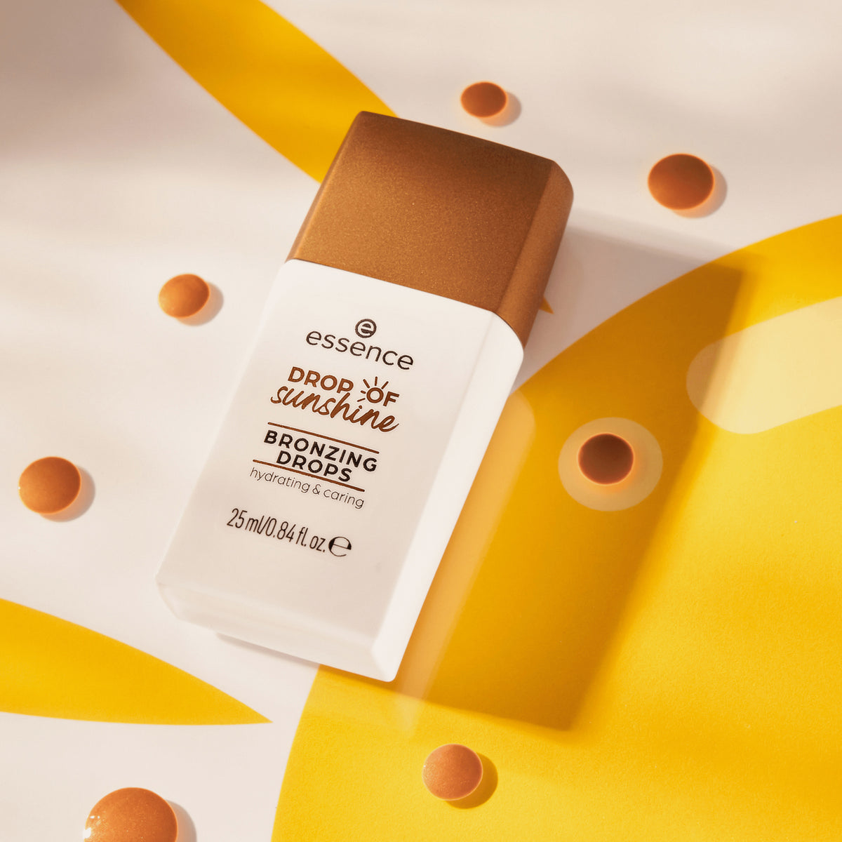 Eine Flasche DROP OF sunshine BRONZING DROPS auf einem leuchtend gelben Hintergrund mit Sonnenmotiv präsentiert.