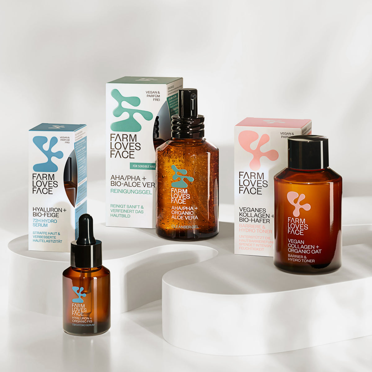 Mehrere Produkte von Farm Loves Face auf weißer Plattform und vor weißem Hintergrund.