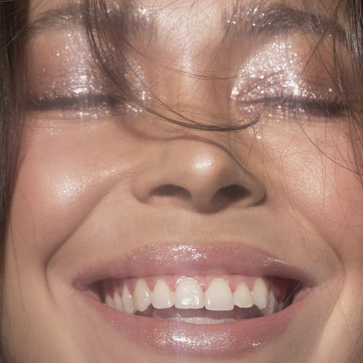 Nahaufnahme einer lächelnden Frau mit rosa glitzerndem Lidschatten Sparkl Delish von LH Cosmetics,