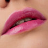 Nahaufnahme der Lippen einer Person mit heller Haut mit dem Glossin‘ Glow Tinted Lip Oil 020 in glänzendem Pink.
