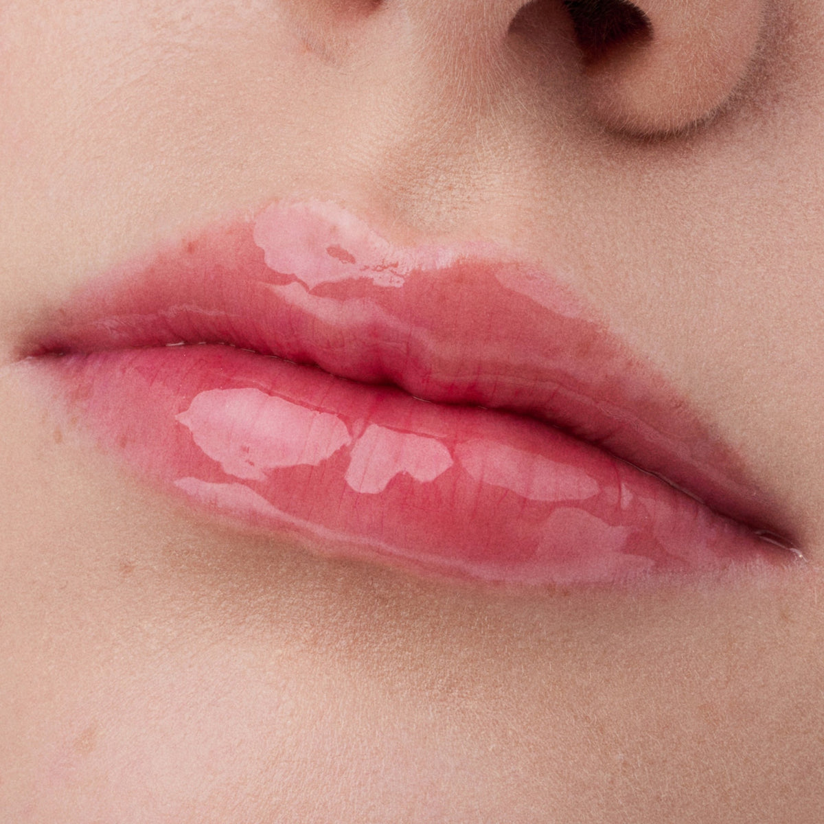 Nahaufnahme der Lippen einer Person mit heller Haut mit dem Glossin‘ Glow Tinted Lip Oil 030.