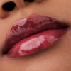 Nahaufnahme der Lippen einer Person mit brauner Haut mit dem Glossin‘ Glow Tinted Lip Oil 030.