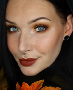 Dunkelhaarige Frau mit blauen Augen und herbstlichem Make-up Look.