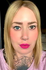 Frau mit blondem Haar und blauer sowie brauner Kontaktlinse und pinkem Lippenstift.