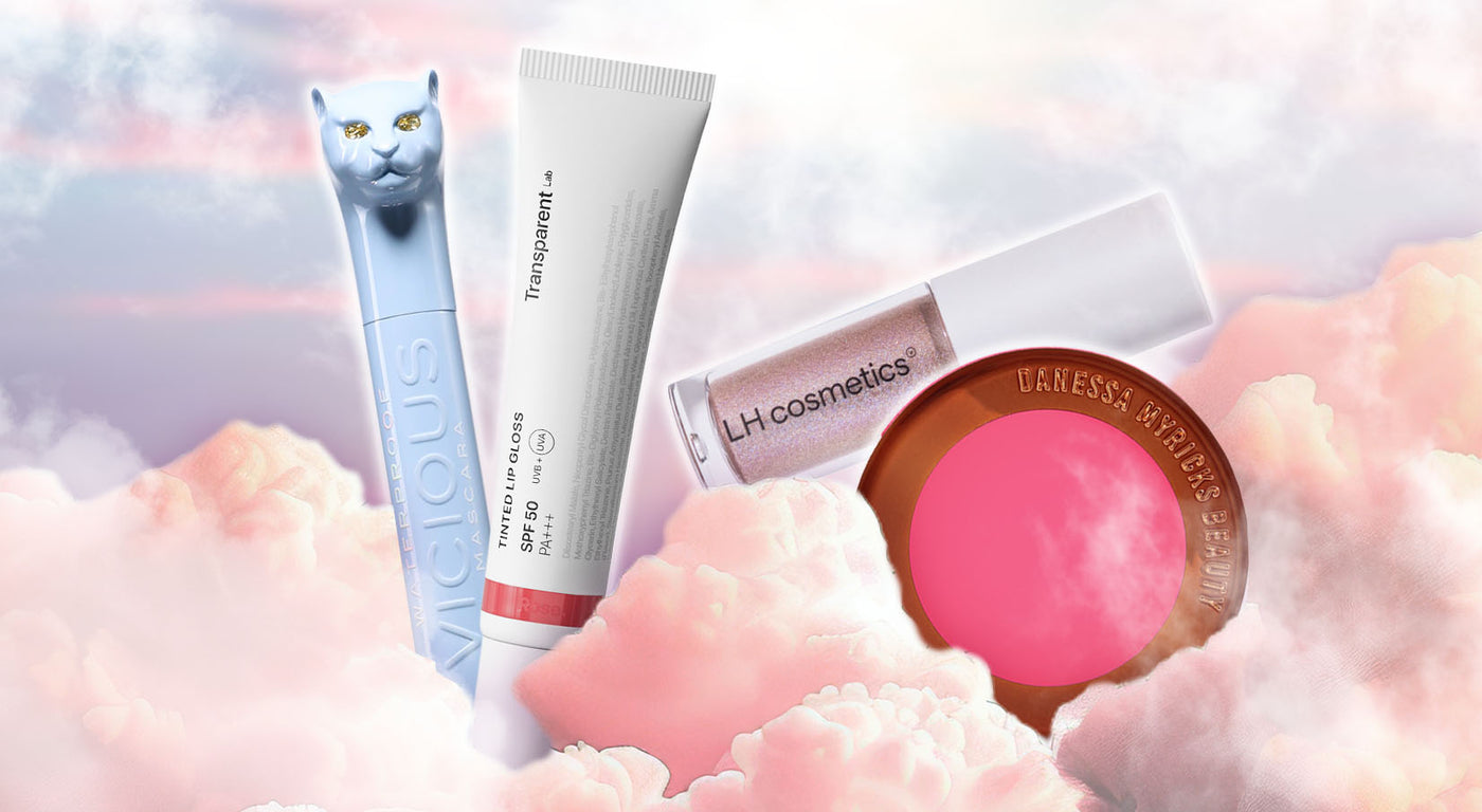 Vier Beauty-Produkte: eine hellblaue Mascara mit Katzenkopf, eine weiße Tube Lip Gloss, ein LH cosmetics Lipgloss und ein pinker Danessa Myricks Blush – schweben vor rosa Wolken.