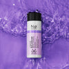 Eine Flasche Calm Tøday Liquid Balancer liegt auf einer violetten Flüssigkeitsoberfläche mit Wellen.