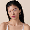Eine Person mit schwarzem Haar und heller Haur präsentiert das Glossin‘ Glow Tinted Lip Oil 020.