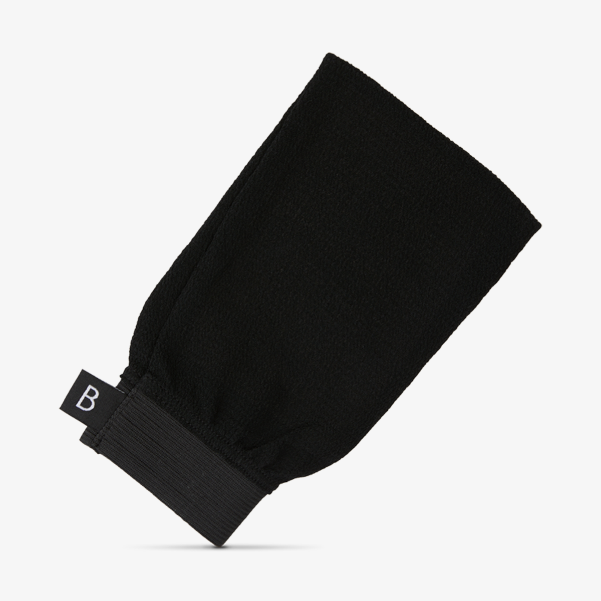Der eckige schwarze Peelinghandschuh "Exfoliating Mitt" mit elastischem Armband und einem kleinen Etikett mit dem Buchstaben „B“