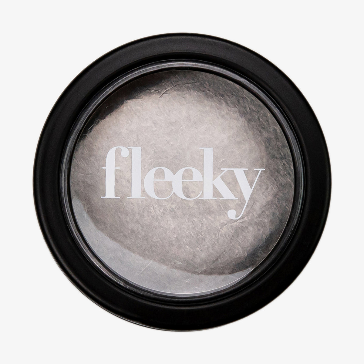 Ein runder schwarzer Behälter mit  durchsichtigem Deckel gibt den Blick auf das transparente Brow Gel frei.