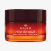 Ein Tiegel NUXE Rêve de Miel® Honig-Lippenbalsam mit braunem Deckel und orange getöntem Behälter.