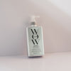 Eine silberne Flasche Dream Coat Supernatural Spray lehnt vor einem hellen Hintergrund.