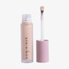 Auf weißem Hintergrund ist eine geöffnete Tube Wide Awake Full Coverage Concealer Cafe con Leche mit rosa Kappe und Applikatorstab abgebildet.