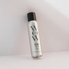 Eine Dose Extra Shine Spray mit schwarzer Kappe steht vor einem hellen Hintergrund.