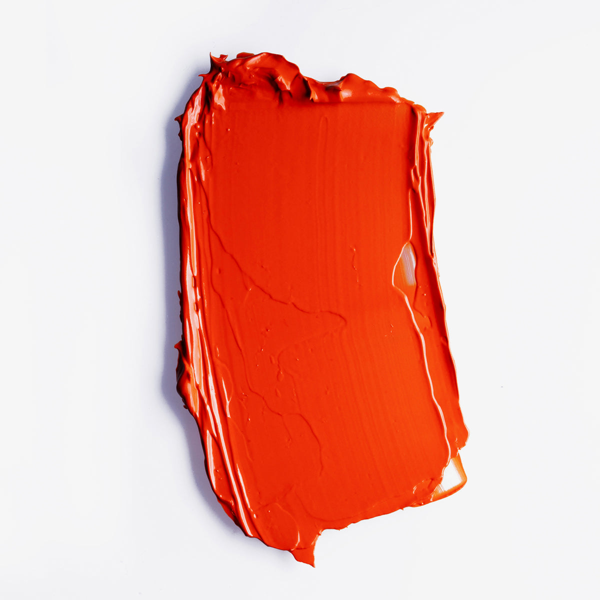 Knalliger orange-roter Farbstreifen des LH Cosmetics Velvet Couture Lippenstift in Orange Red auf weißem Hintergrund.