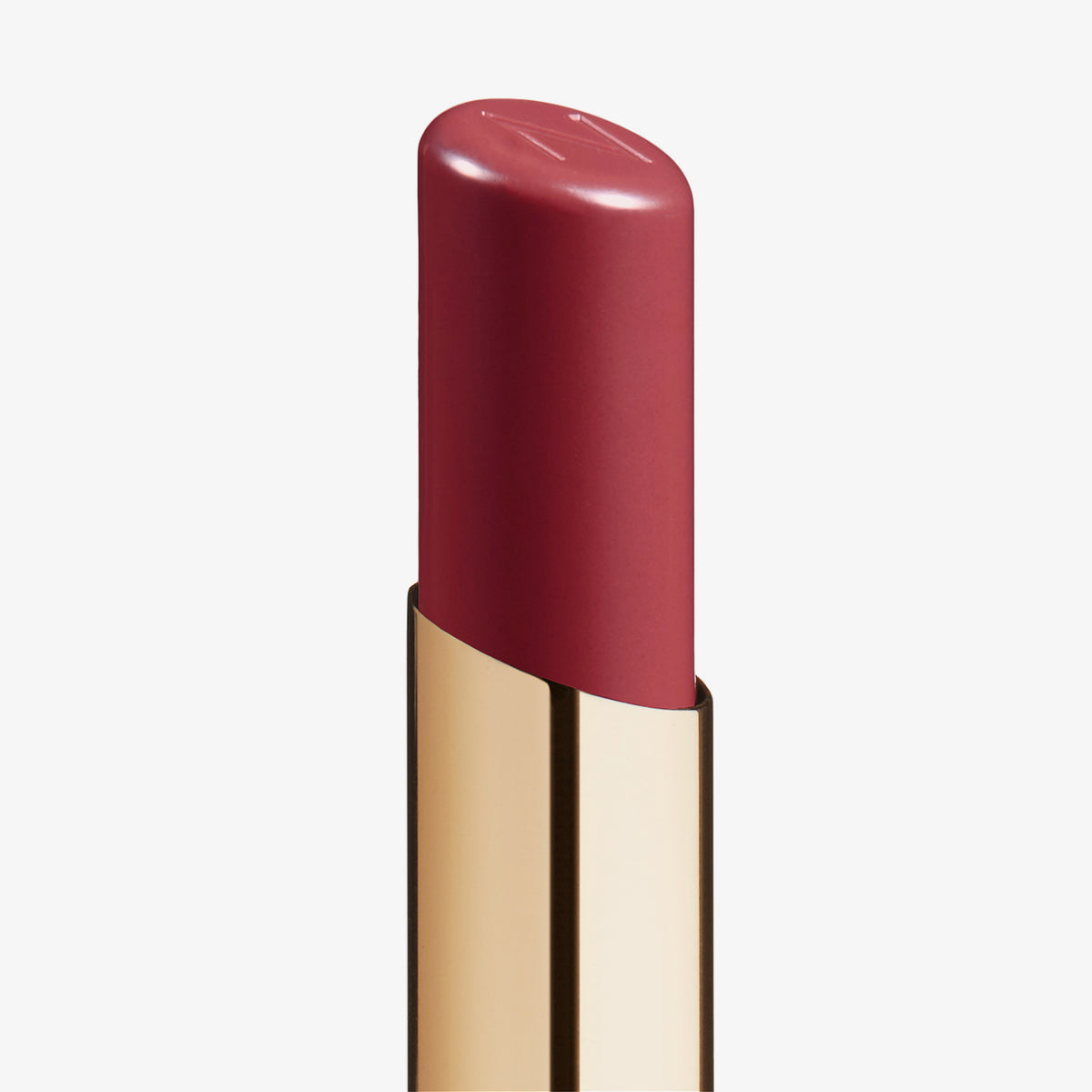 Eine Nahaufnahme des Beyond Jelly Lipstick in der Farbe Libido in einer glänzenden goldenen Hülse vor weißem Hintergrund.