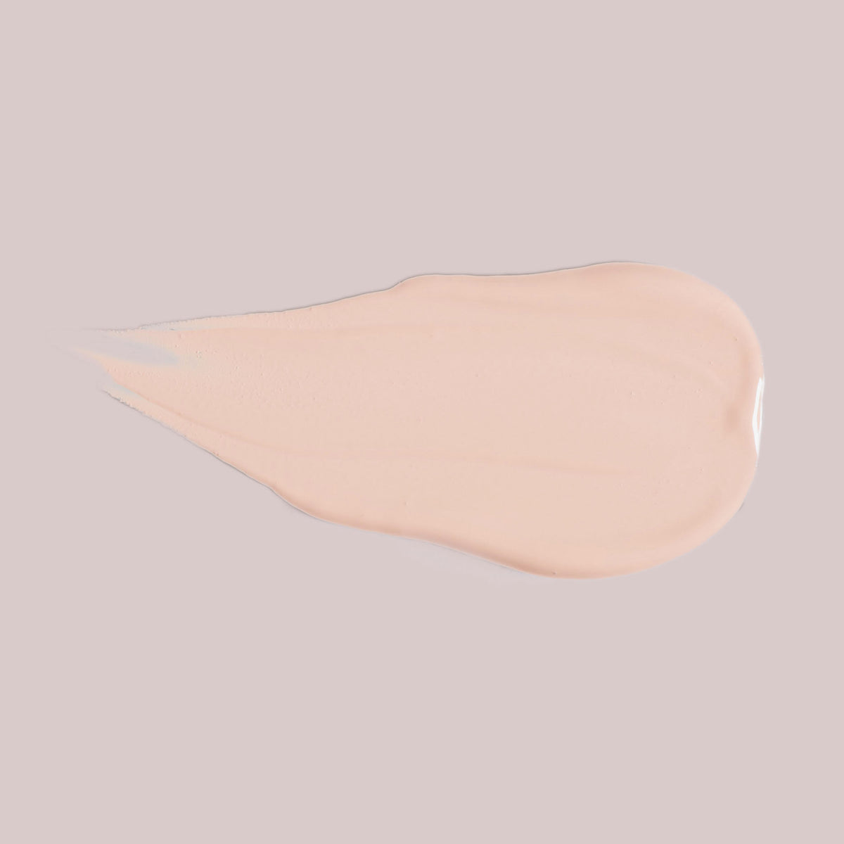 Ein Klecks Wide Awake Full Coverage Concealer, eine hellbeige Flüssigkeit, auf hellgrauem Hintergrund.