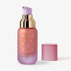 Eine rosa-goldene Flasche Angel Aura Radiant Plumping Serum Primer ohne Deckel.