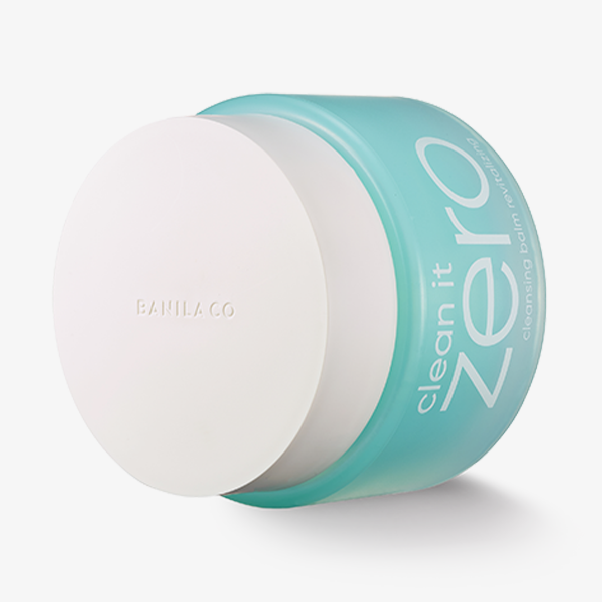 Ein türkisfarbener auf der Seite liegender Tiegel Banila Co Clean It Zero Cleansing Balm Revitalizing mit weißem Deckel vor weißem Hintergrund
