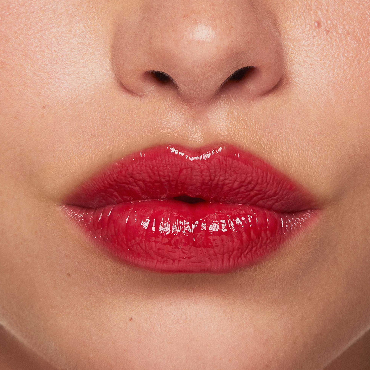 Auf dem Bild ist eine Nahaufnahme der Lippen zu sehen, die den Beyond Jelly Lipstick in der Farbe Red Sapphire aufgetragen haben.