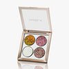 Die Glorious Lights Glitter Palette enthält vier glitzernde Lidschattentöne – Gold, Pink, Weiß und Bronze – in einem quadratischen Etui.