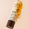 NUXE Rêve de Miel® Lippenpflegestift mit Honig und Sonnenblume, umgeben von herabrinnendem Honig.