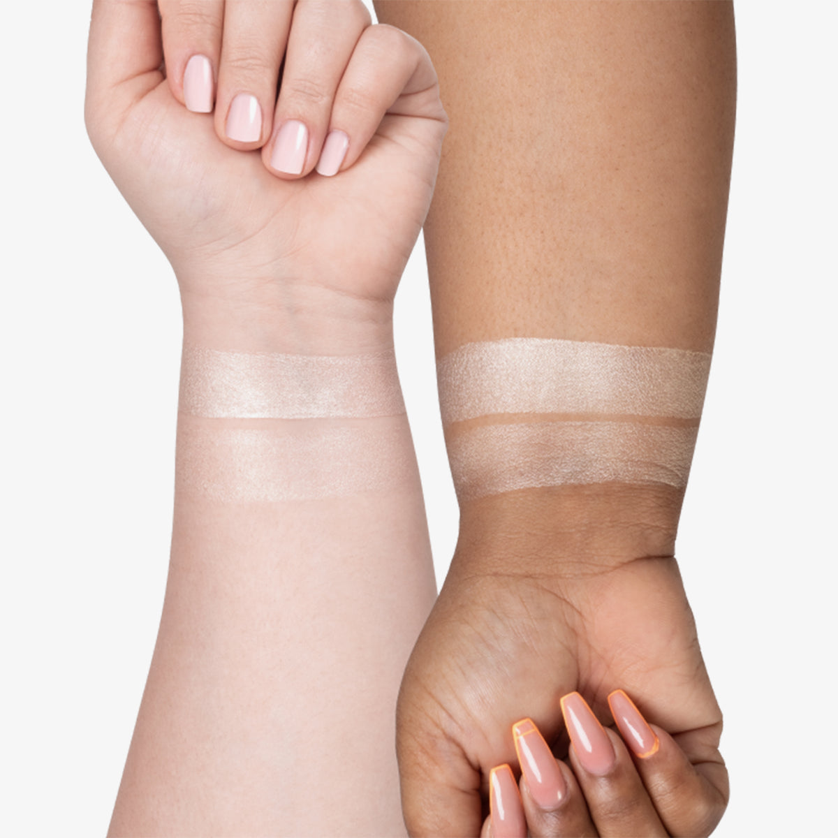 An den Handgelenken zweier Arme mit unterschiedlichen Hauttönen schimmern Farbmuster des Liquid Highlighter von OFRA Cosmetics.