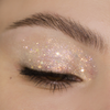 Nahaufnahme eines geschlossenen Auges mit dem weißen Glitzer-Lidschatten aus der NABLA „Miami Lights“ Palette – aufgetragen über das gesamte Lid mit intensiv funkelndem, mehrfarbigem Finish.